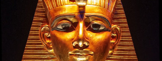 An ancient pharaoh's head in full gold, zoomed in closely to the face.