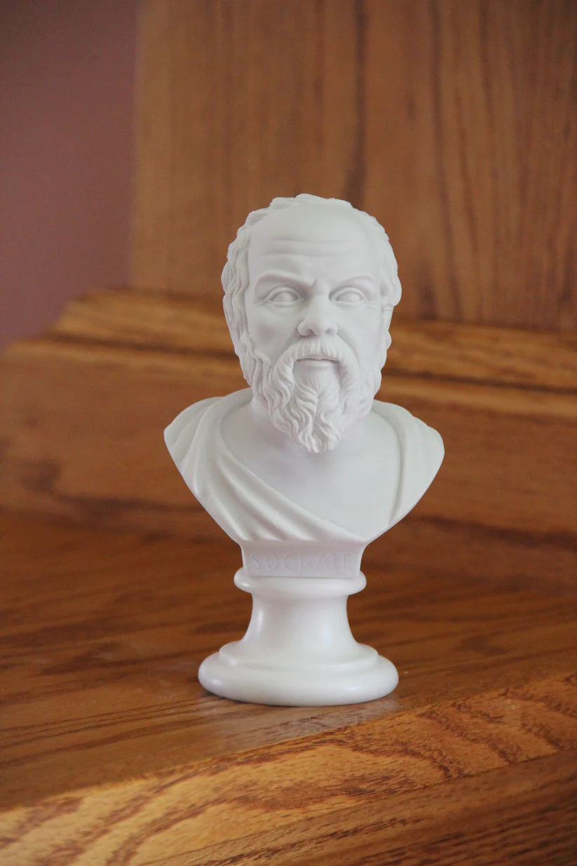 Bust of Socrates in white marble finish on wooden shelf.