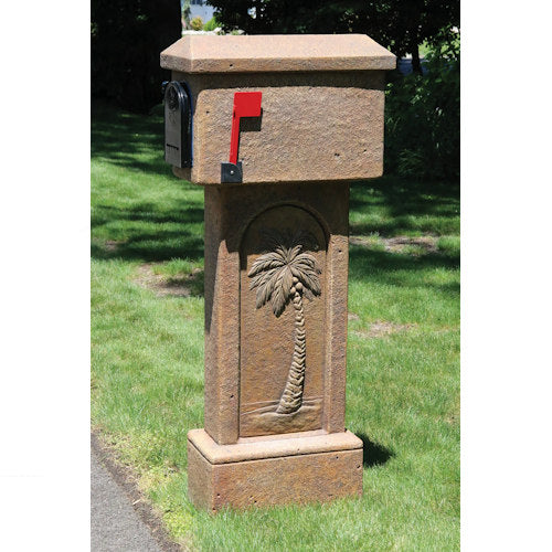 Decorative mailbox with palm tree relief design on a grassy lawn