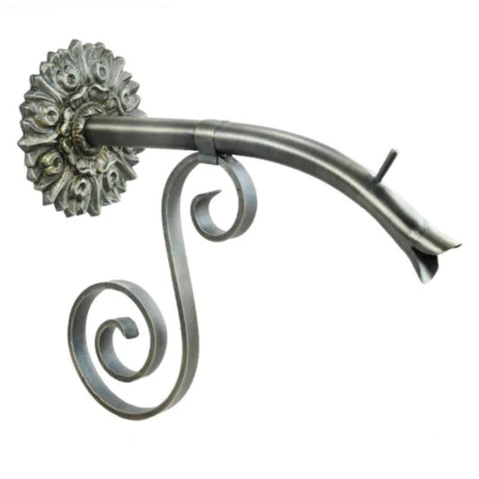 Ornate metal spout with floral wall mount and elegant double scroll support bracket.