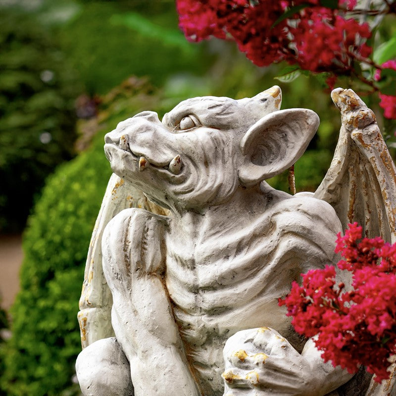 Close up gargoyle statues set face of one outdoor garden Sculptures
