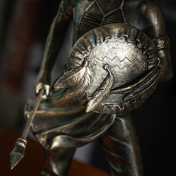 Close up statue depicts a Native American warrior shield sculpture