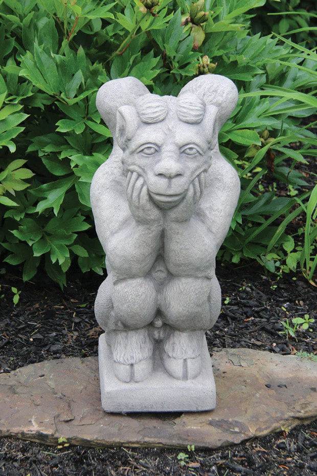 Stone statue of a mythical creature on a garden path with greenery in the background