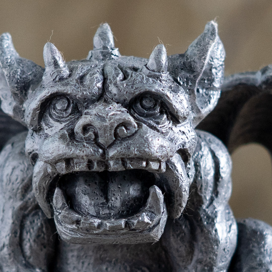 Close-up of a stone gargoyle sculpture with detailed features.