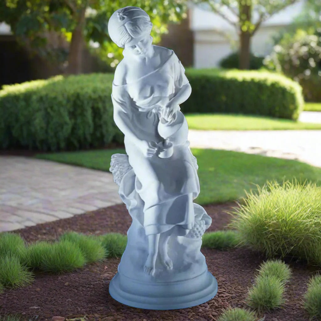 25.25-inch Italian marble Maiden with Jug statue, displayed in an outdoor garden with trimmed greenery.