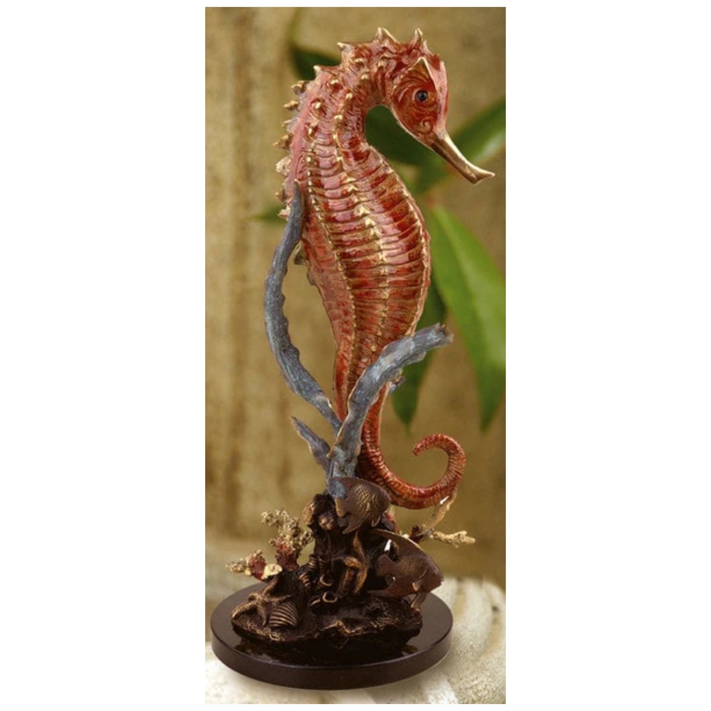 This elegant sculpture features a vibrant bronze/brass seahorse wrapped delicately around a piece of coral. The seahorse has a glossy reddish-orange finish with intricate detailing on its body and fins.