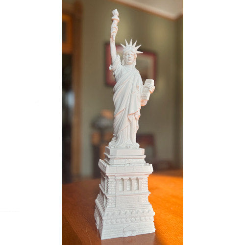 Statue of Liberty model on a wooden surface with a blurred background