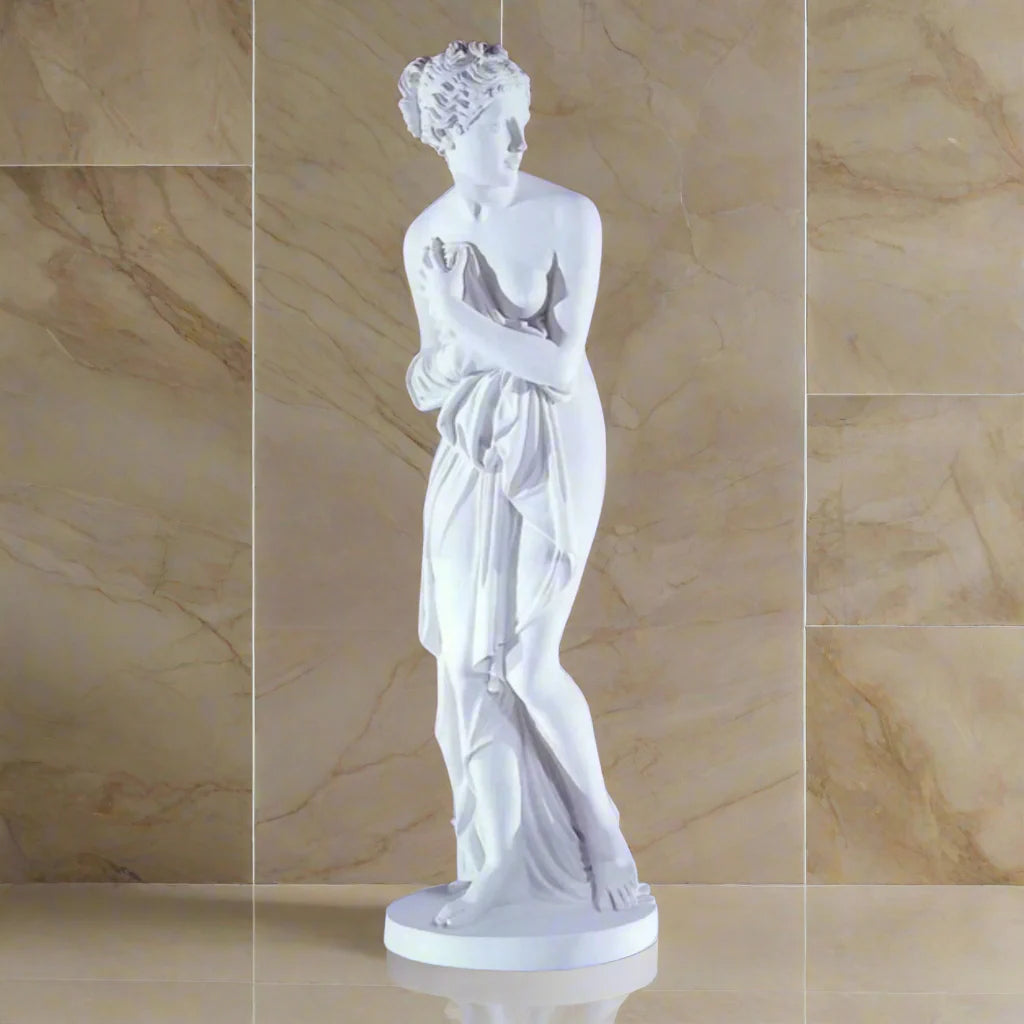 Canova-inspired Venus Italica marble statue on a clean light orange marble background
