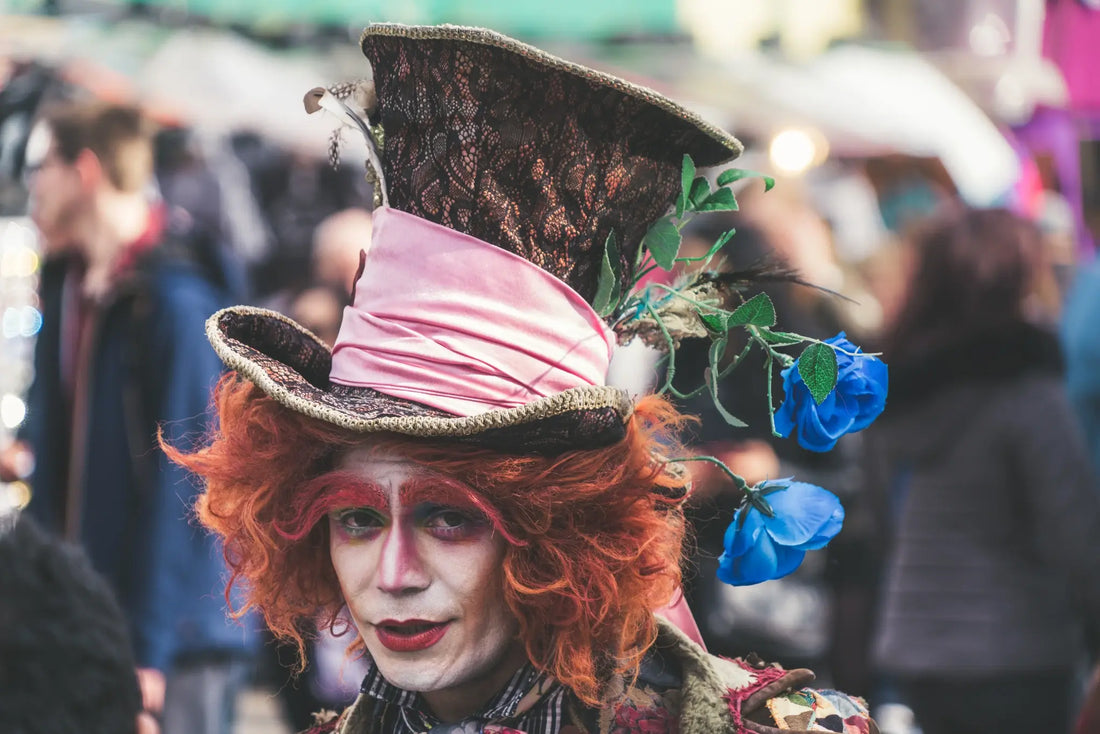 A real life "Mad Hatter" with a pale face, large hat, and wild red hair.