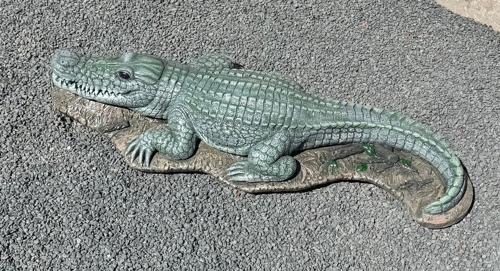 Bronze alligator sculpture on a textured surface water fountain piped statue