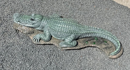 Bronze alligator sculpture on a textured surface water fountain piped statue