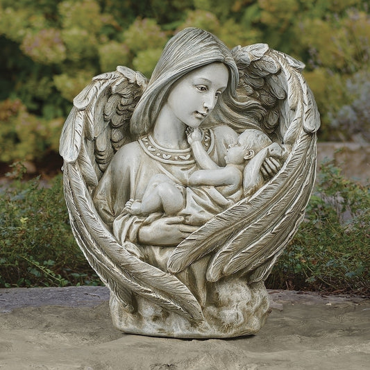 Statue of an angel holding a baby with wings spread wide, outdoors.