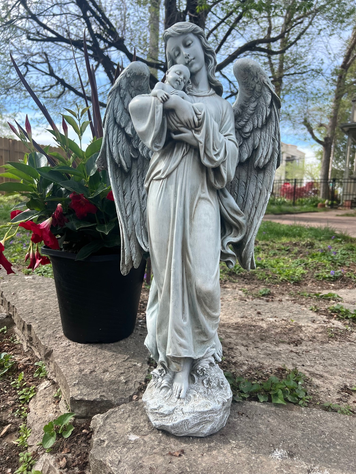 memorial angel statue holding infant serene expression seen outdoors