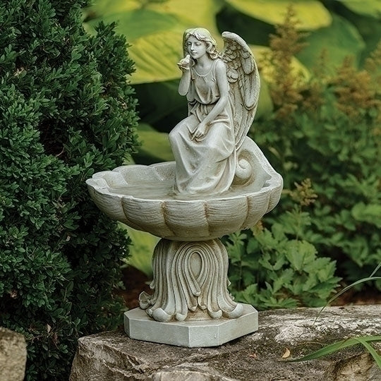 Statue of an angel sitting on a decorative pedestal in a garden setting