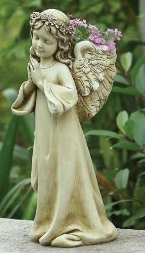 Statue of an angel with wings and a flower crown on a natural background