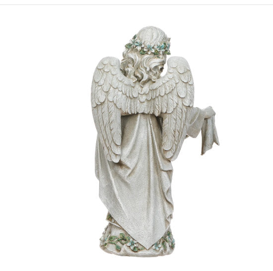 Statue of an angel with wings spread on a white ground back view of sculpture