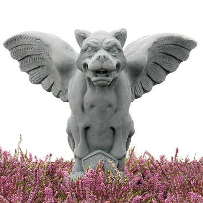 A gray stone gargoyle statue with spread wings, shown above a bed of pink heather flowers against a white background. Architectural colors