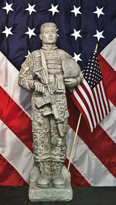 Camo Soldier with Flag Statue  Holding Rifle and helmet 