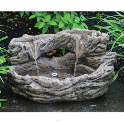 Decorative stone water fountain with flowing water in a garden setting