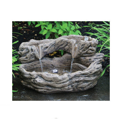 Decorative stone water fountain with water flowing in a garden setting