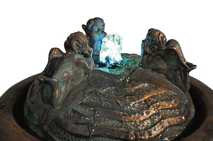 Close up of Cherub Trio Bubbler Garden Fountain watching the flow of water lighted feature