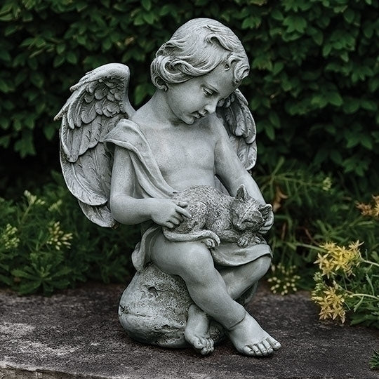 Statue of an angel holding a cat in a garden setting