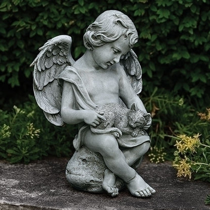Statue of an angel holding a cat in a garden setting