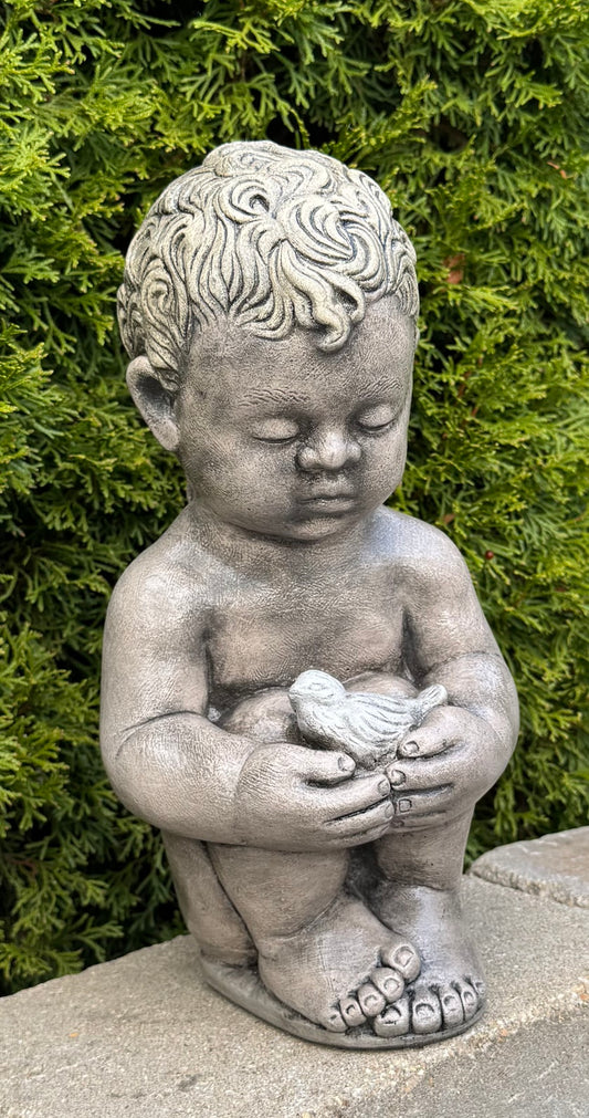 Child Holding Bird garden statue captures a tender moment frozen in time