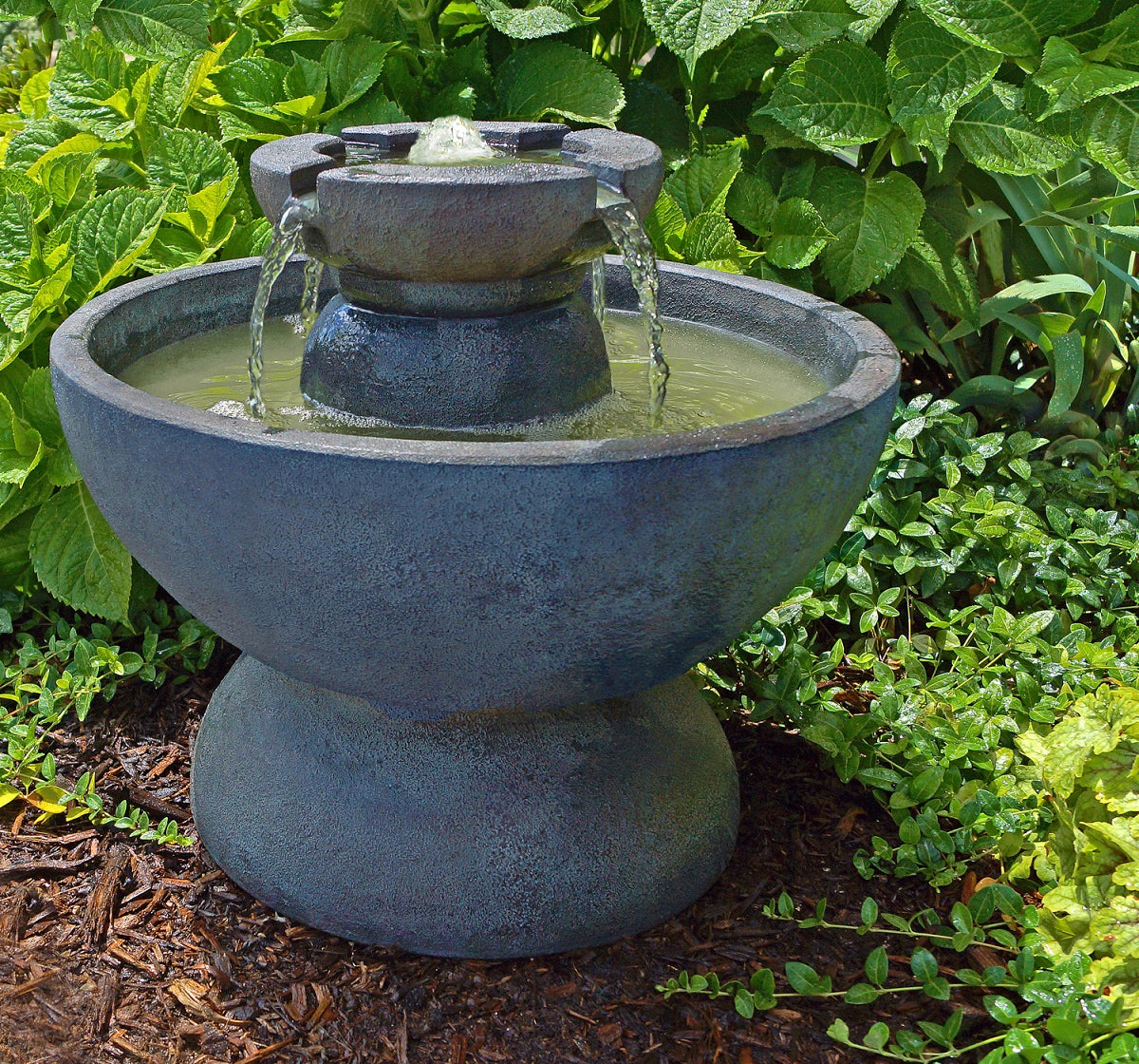 Round Copa Garden Decorative outdoor water fountain with greenery in the background
