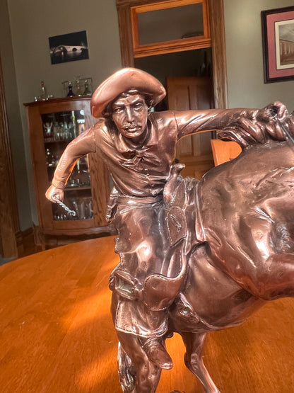 Detailed cowboy breaking a wild horse Western sculpture face and clothing