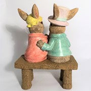 back View Hand-painted bunny couple sitting on a bench holding a basket of Easter eggs