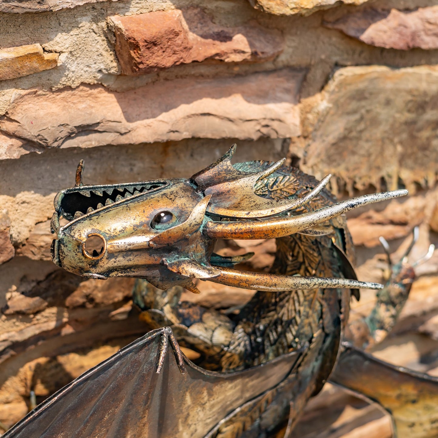 Horned Guardian Serpent wall dragon sculpture with coiled body and spread wings mounted on stone wall