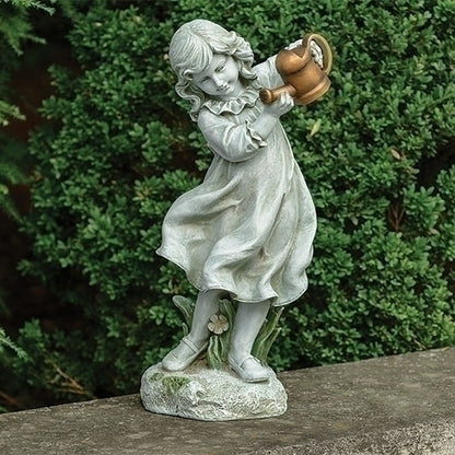 Statue of a girl holding a watering can against a green bush background