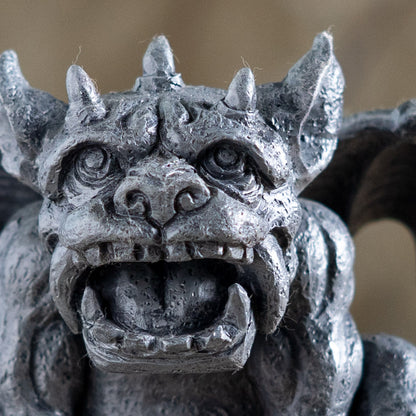 Close-up of a stone gargoyle sculpture with detailed features.