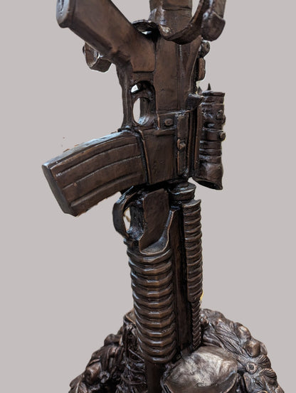 Bronze sculpture of a gun on a gray background battle boots memorial bronze statue