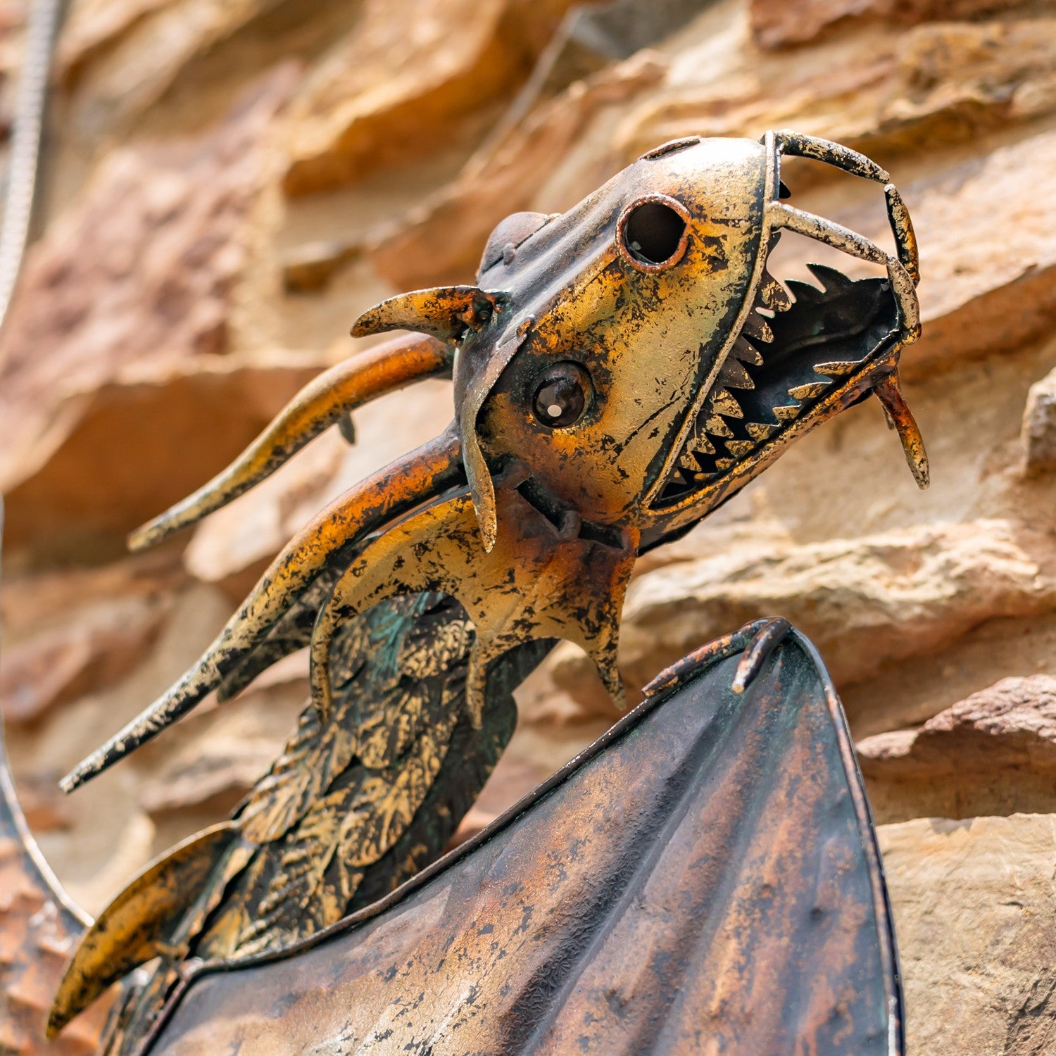 Close up of head Guardian Serpent wall dragon sculpture with coiled body and spread wings mounted on stone wall