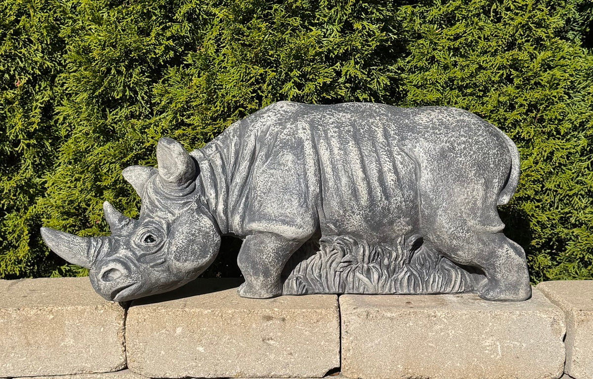 Grazing rhinoceros outdoor sculpture measuring 30 inches wide