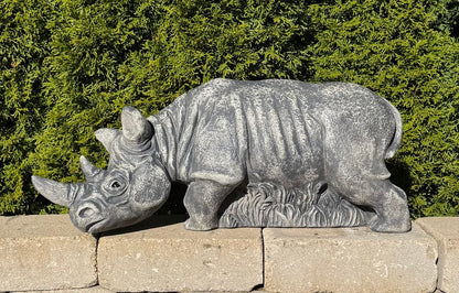 Grazing rhinoceros outdoor sculpture measuring 30 inches wide