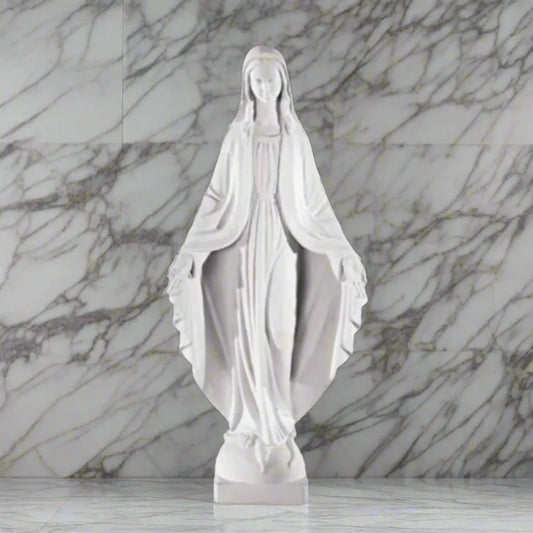 Bonded marble statue of the Immaculate Virgin Mary, displayed in a serene garden with lush greenery and a natural stone path