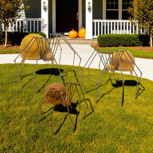 Set of three metal spider garden sculptures with distressed iron finish displayed on lawn