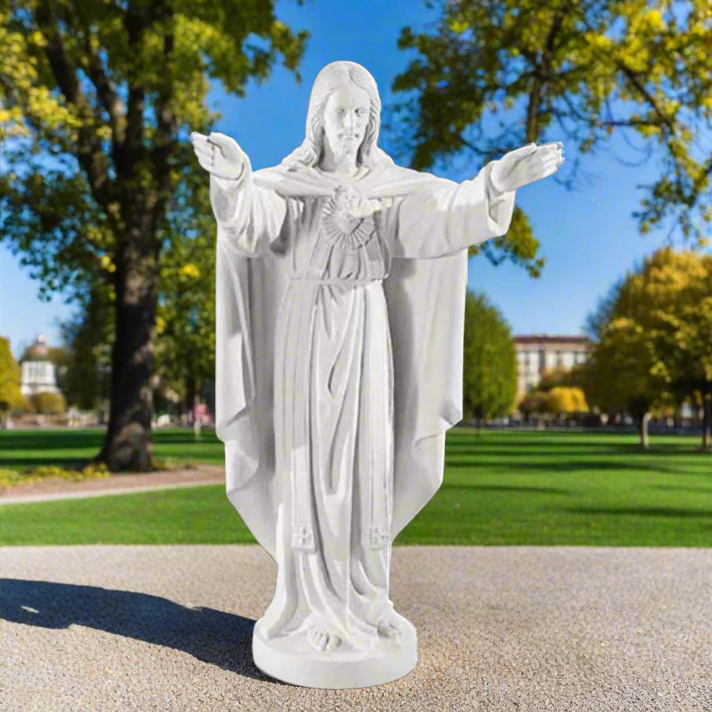 32-inch Sacred Heart of Jesus statue in Italian marble, displayed in a peaceful outdoor setting with manicured greenery and soft lighting