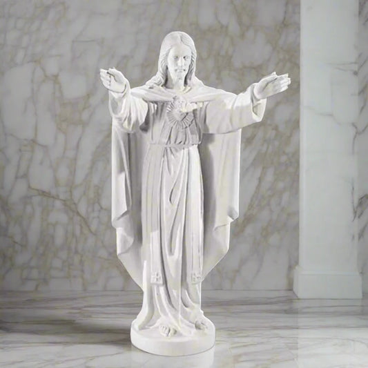 32-inch Sacred Heart of Jesus statue in Italian marble, displayed in a peaceful outdoor setting with manicured greenery and soft lighting