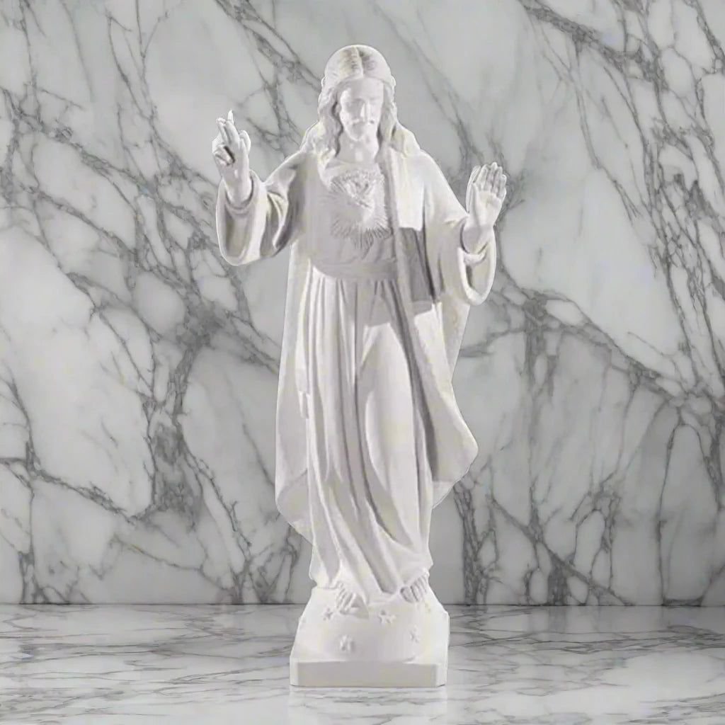32-inch Sacred Heart of Jesus statue in Italian marble, displayed in a peaceful outdoor setting with manicured greenery and soft lighting