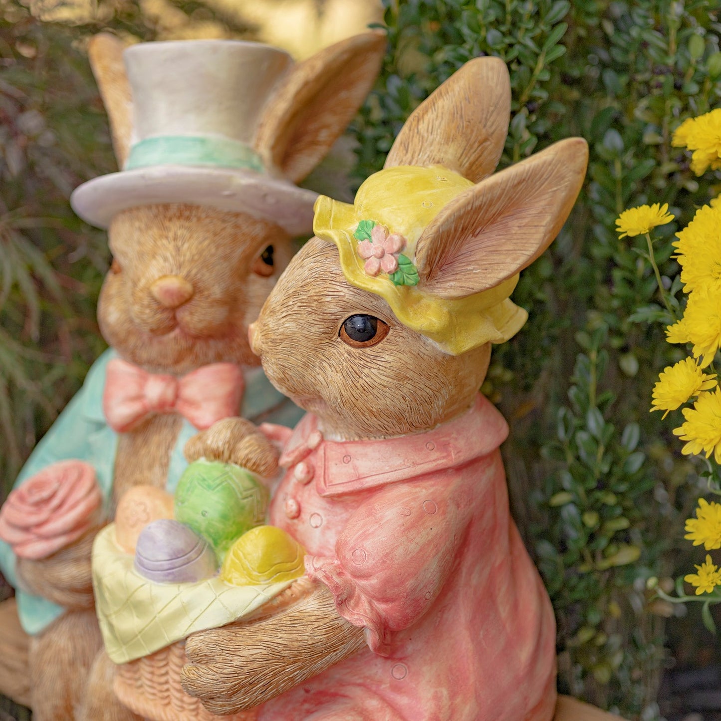 Close up of faces Hand-painted bunny couple sitting on a bench holding a basket of Easter eggs