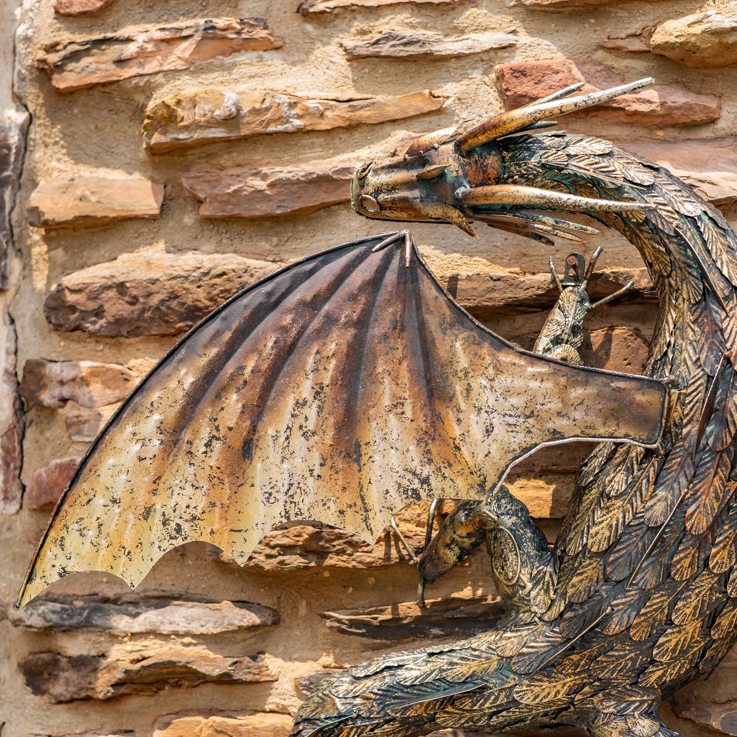 Winged Guardian Serpent wall dragon sculpture with coiled body and spread wings mounted on stone wall