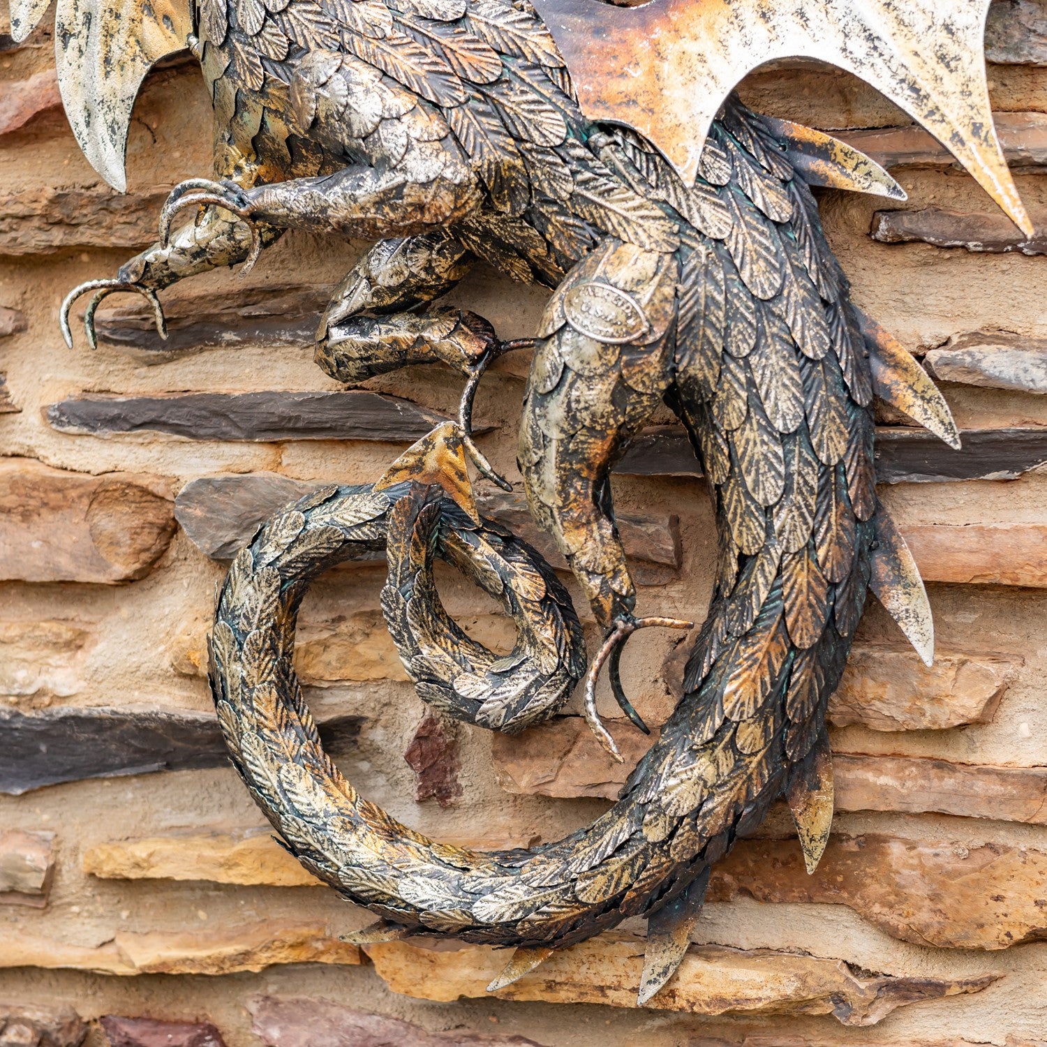Close up of tail Metal serpent dragon wall hanging sculpture with coiled body and wide wings
