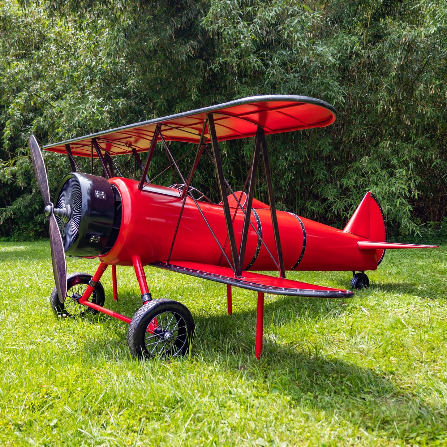 Large 10-foot red metal biplane decorative sculpture with seat and LED lighting displayed on grass