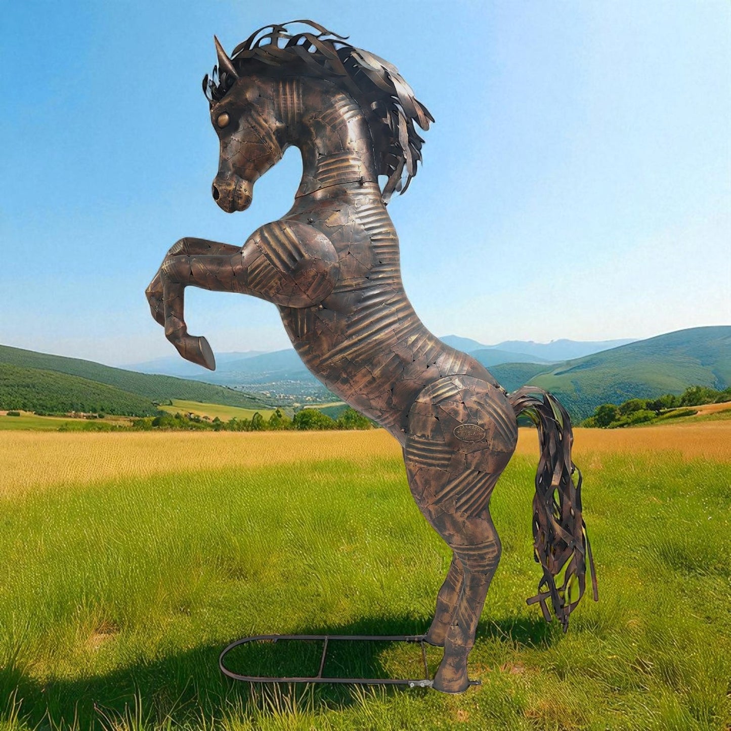 Bronze horse sculpture in a field with mountains in the background