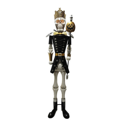 A full-length skeleton nutcracker figurine dressed in a black military-style uniform with gold trim, a gold crown, and a small jack-o'-lantern accessory, shown against a plain white background.
