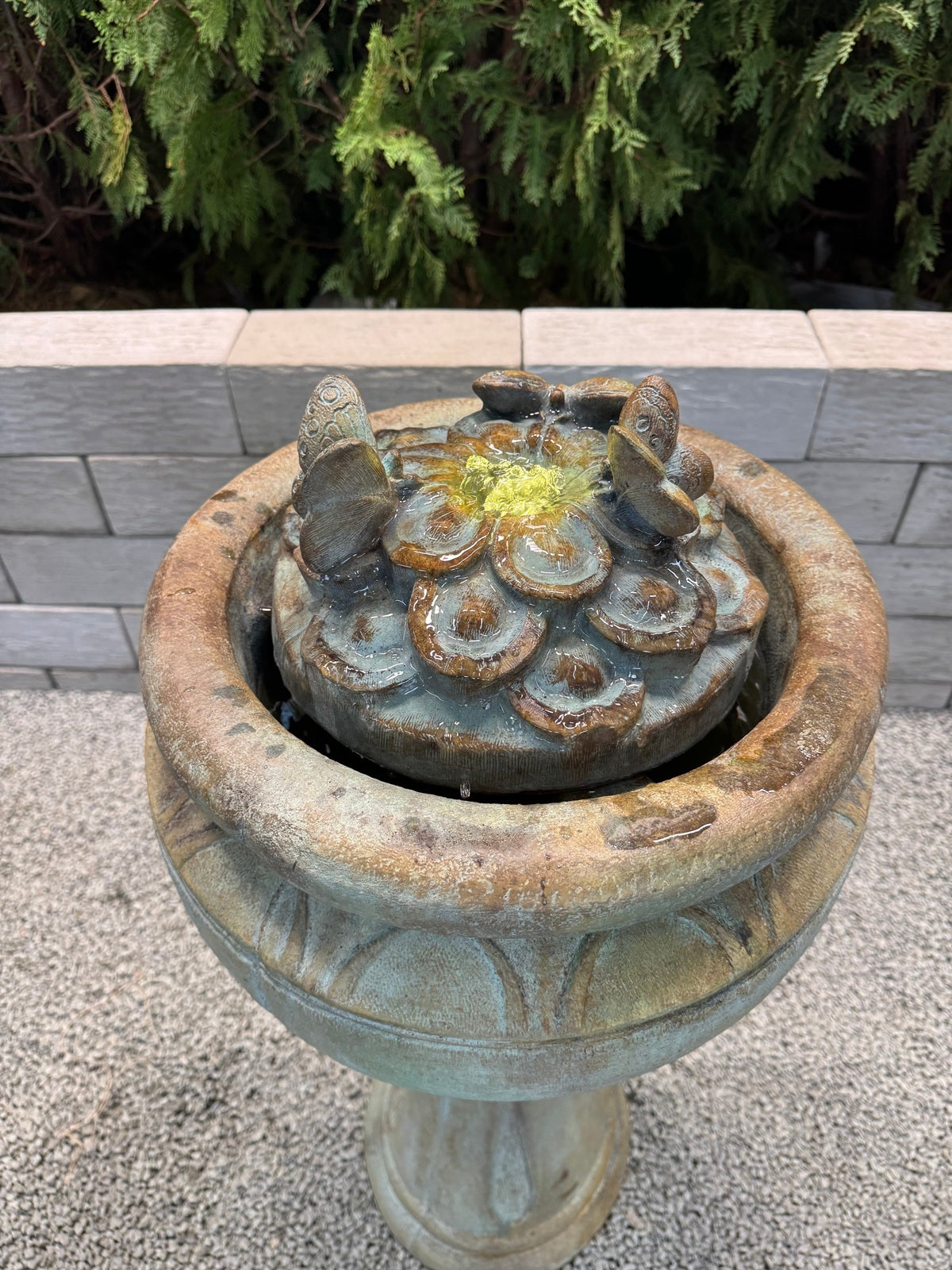 Nature-inspired cast stone fountain with butterflies close up of top of water feature